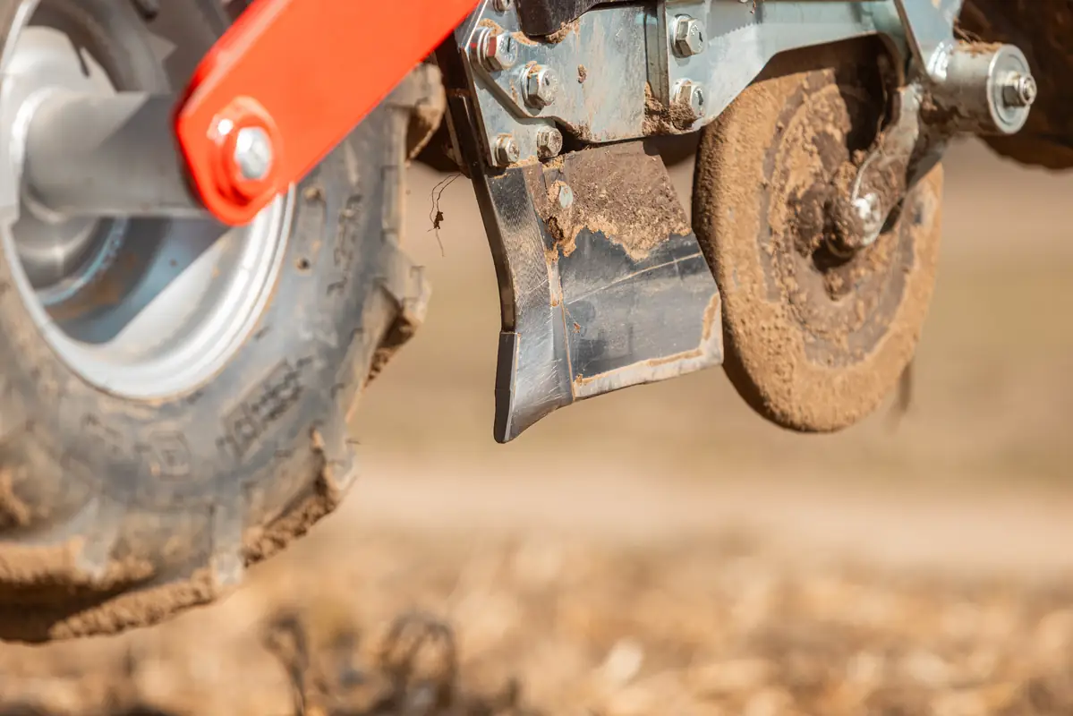 Knurled coulter of the Czajkowski PSP planter beside the row-unit wheel in the field.